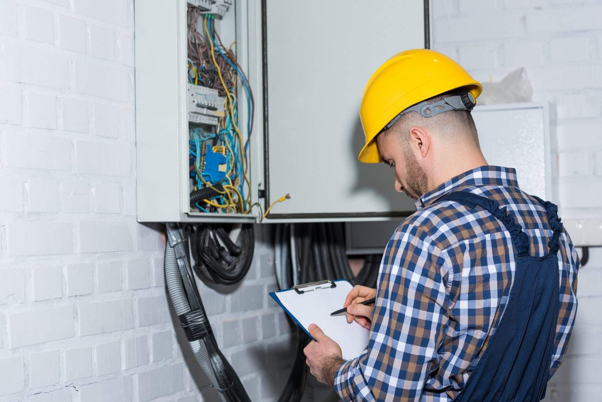 professional-electrician-inspecting-wires-in-electrical-box